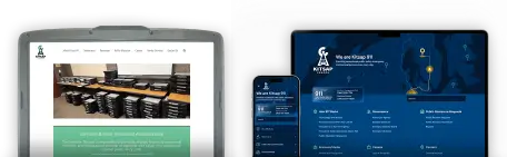 On the left, an older model laptop screen displaying the previous Kitsap 911 website layout, consisting of a logo, single menu bar, a hero image of stacked electronic hardware, and illegible white text on a light teal background; on the right, a similarly-sized but newer model laptop screen and phone screen displaying the new Kitsap 911 website in dark blue, including logo and introduction over a stylized map of Kitsap County, a callout box with emergency numbers, search, and a set of links in six blocks.